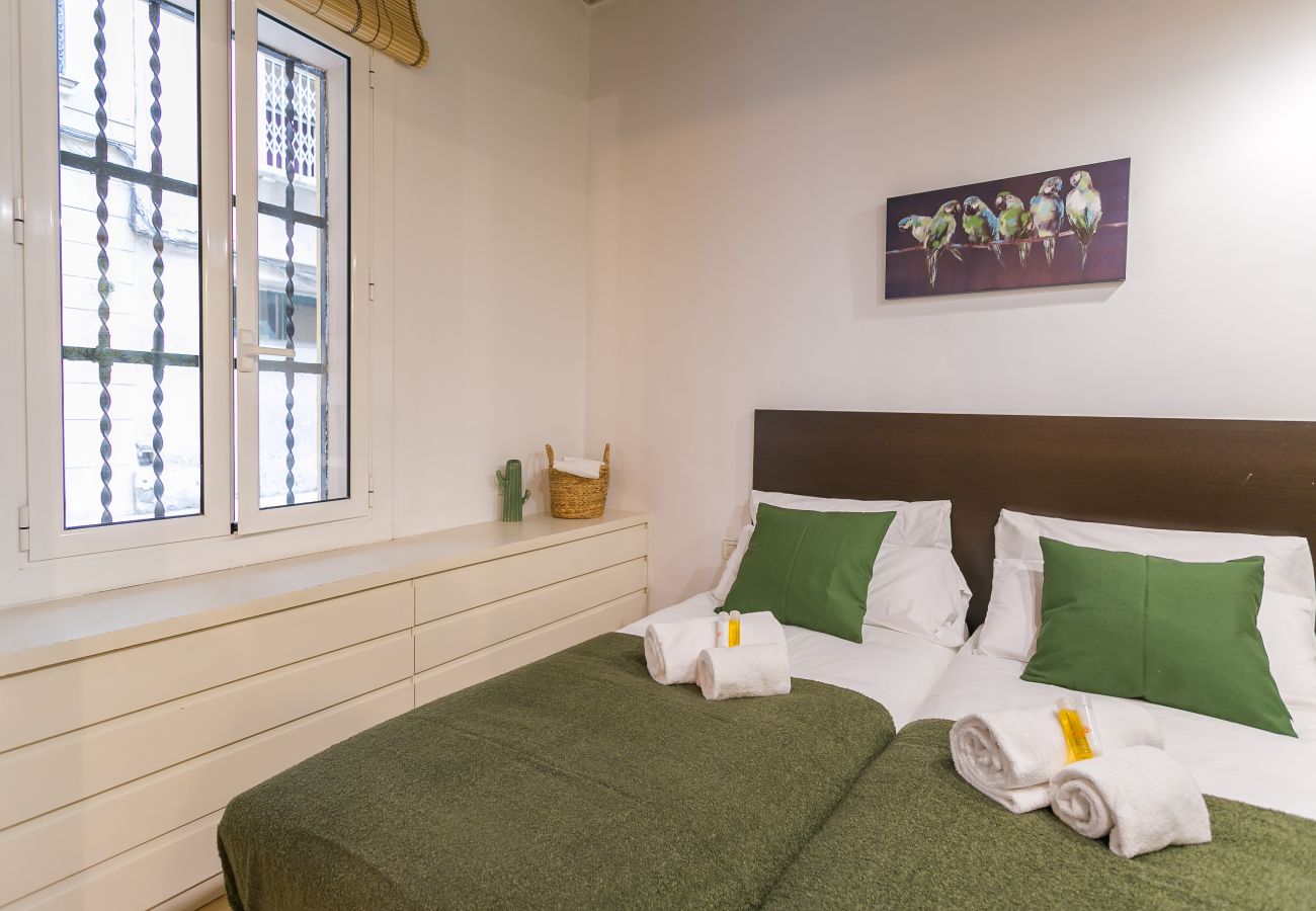dormitorio con 2 camas individuales, armario y ventana exterior